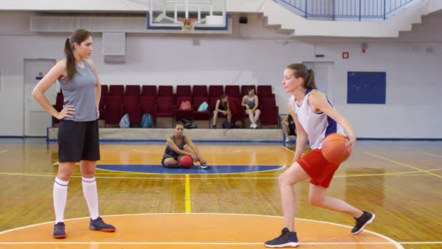 Jóvenes-Atletas-de-Baloncesto-Femenino-Teniendo-Entrenamiento-De-Pareja-en-la-Cancha