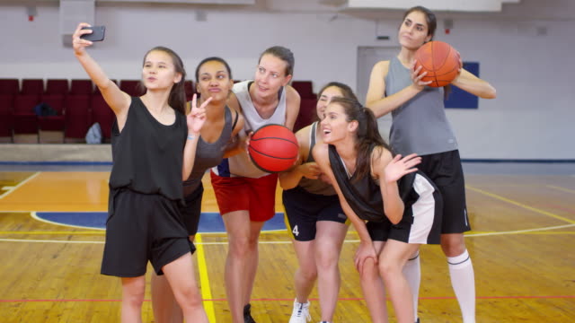 Junges-weibliches-Basketballteam-macht-Selfie-mit-Smartphone