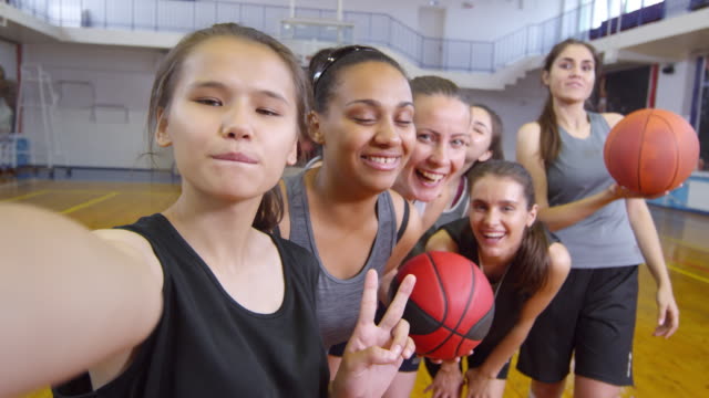 POV-von-Basketballspielerinnen-lächelnd-vor-der-Kamera-und-posiert-für-Selfie