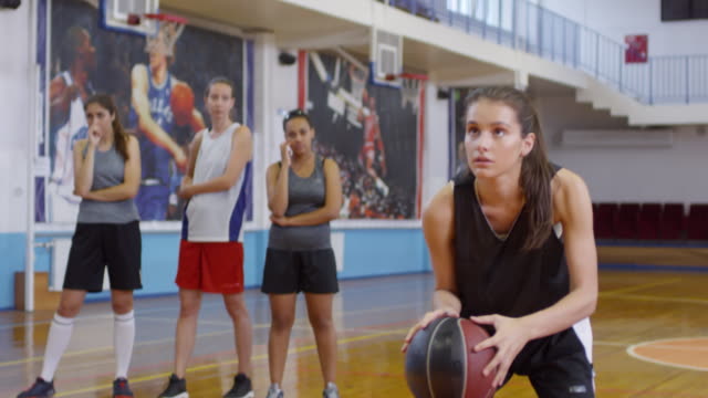 Chica-disparando-un-baloncesto-y-celebrando-el-éxito-con-el-equipo-femenino