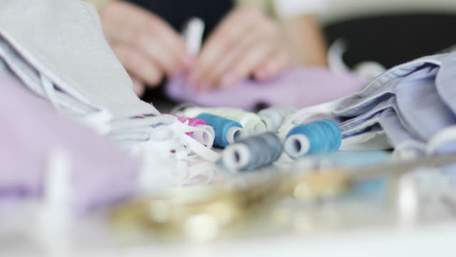 Close-up-of-accessories-for-sewing:-threads,-scissors,-fabric.-Woman-sews-medical-masks-at-home.