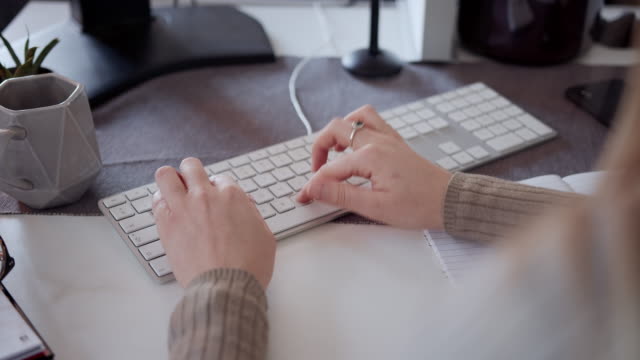 Mujer-anónima-trabajando-en-el-teclado-y-tomando-notas