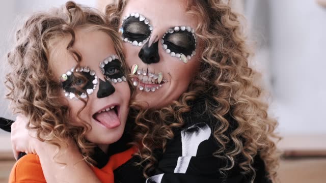 Portrait-of-mother-and-daughter-with-curly-hair-wearing-costumes