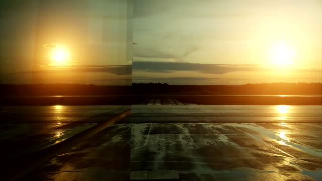 Reflexión-en-la-ventana-del-aeropuerto-de-un-avión-de-despegue-durante-la-puesta-del-sol