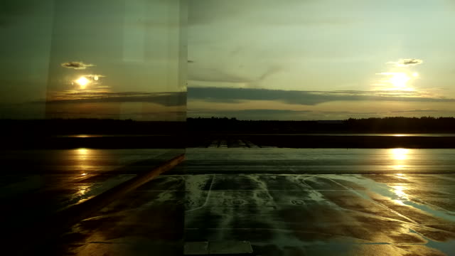 Reflexion-im-Flughafenfenster-eines-Startflugzeugs-bei-Sonnenuntergang