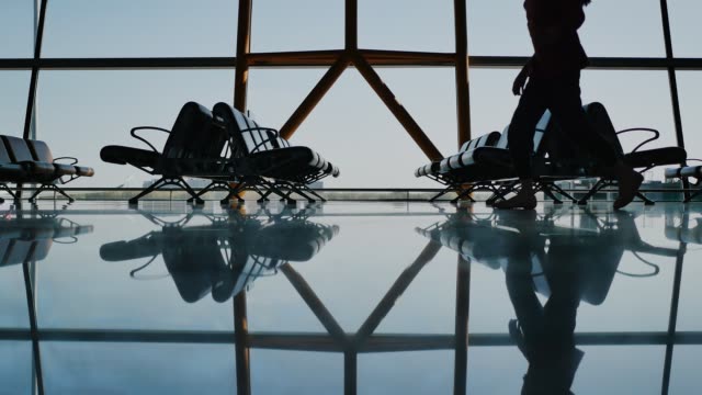 Silhouette-Gruppe-von-Passagieren-zu-Fuß-mit-Gepäck-am-Flughafen