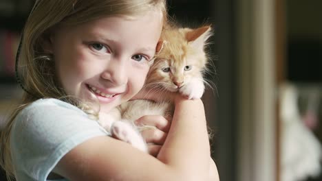 Ein-kleines-Mädchen-halten-Katze-und-Lächeln