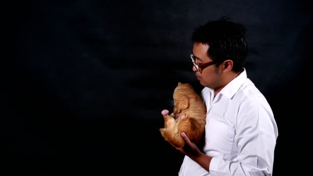 männliche-Tierarzt-tragen-und-eine-Katze-mit-Sorgfalt-zu-spielen.