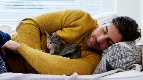 Young-man-sleeping-on-sofa-holding-his-pet-cat-in-his-arms-4K-4k