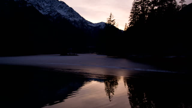 Frozen-lake-near-Mont-Blanc-and-ducks,-sunset,-slowmotion