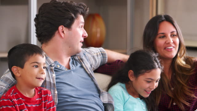 Familie-sitzt-auf-dem-Sofa-vor-dem-Fernseher-und-Essen-Popcorn