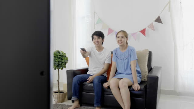 4K:-lenta-de-familia-asiática-feliz-viendo-la-televisión-juntos