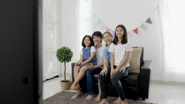 4K:-lenta-de-familia-asiática-feliz-viendo-la-televisión-juntos,-alejar-de-tiro