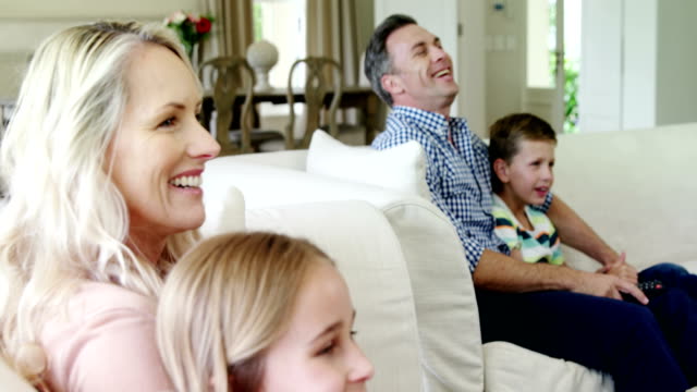 Familia-feliz-viendo-la-televisión-juntos-en-la-sala-de-estar
