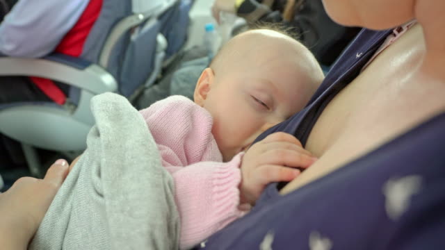 Lactancia-materna-de-una-mujer-de-su-hijo-en-un-avión