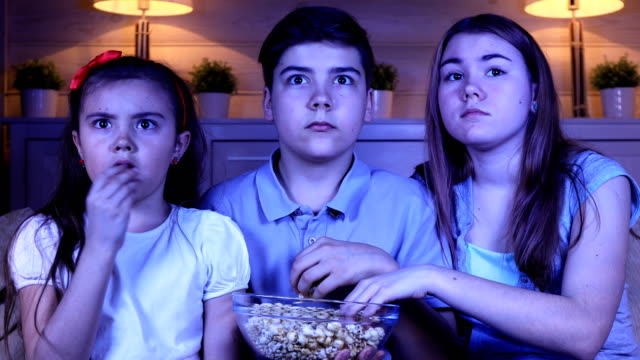 Niños-viendo-una-película-de-terror-en-la-TV