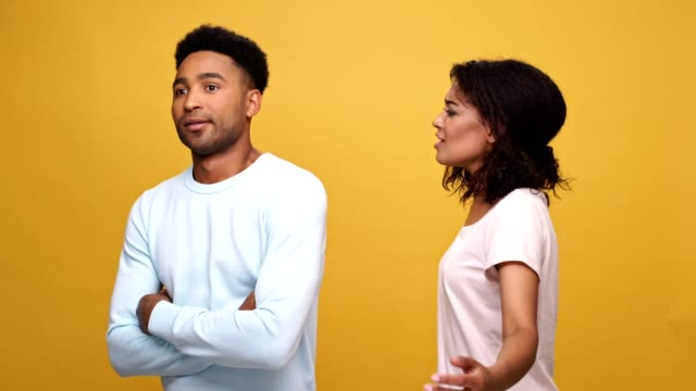 Young-afro-american-couple-having-a-fight-isolated-over-yellow-background