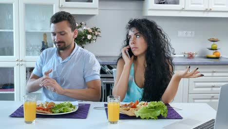 Mann-ist-während-des-Frühstücks-verärgert-wegen-Frau-Gespräche-am-Telefon