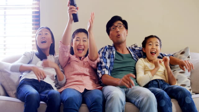 Excited-family-watching-television-together-in-living-room-4k