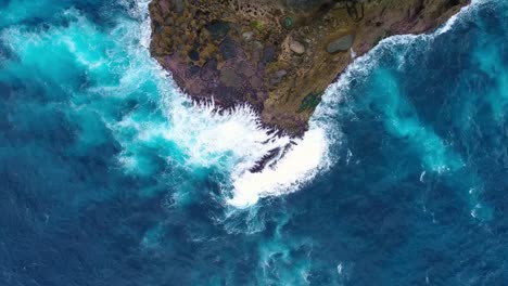 Cliff-with-waves-crashing-against-a-rocky-shore,-Nusa-Penida,-Indonesia.