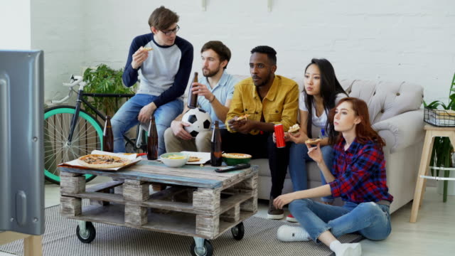 Glückliche-Freunde-Sport-Fans,-die-Fußball-EM-im-Fernsehen-zusammen-Pizza-essen-und-Bier-zu-Hause-beobachten