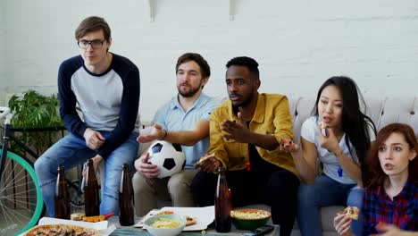 Jóvenes-amigos-viendo-el-partido-de-fútbol-en-la-televisión-juntos-en-casa-y-decepcionada-sobre-su-equipo-perder-el-partido