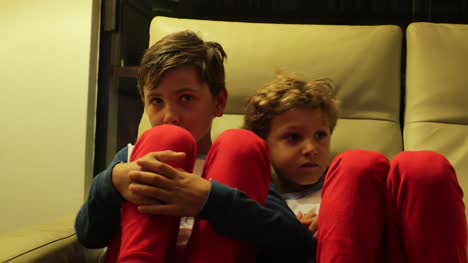 Boys-seated-on-sofa-watching-TV-off-camera.-4K-candid-clip-of-children-watching-screen