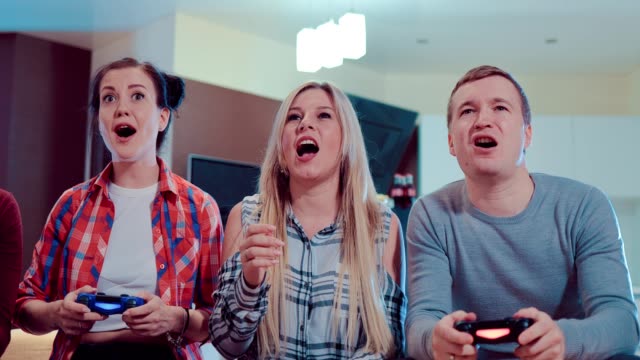 Grupo-de-amigos-que-juegan-video-juegos-en-piso-moderno