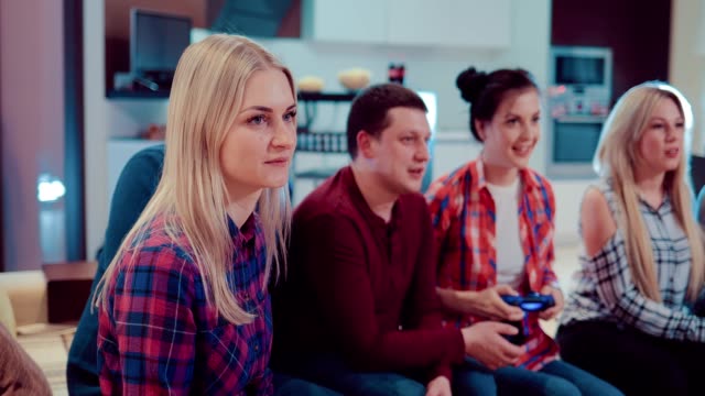 Happy-group-of-friends-socializing-at-home-and-playing-video-game