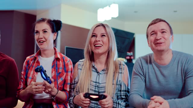 Happy-group-of-friends-socializing-at-home-and-playing-video-game