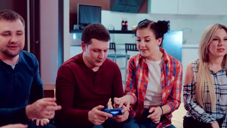 Glückliche-Gruppe-des-Lachens-männliche-und-weibliche-Freunde-spielen-von-Videospielen-mit-wireless-Controller