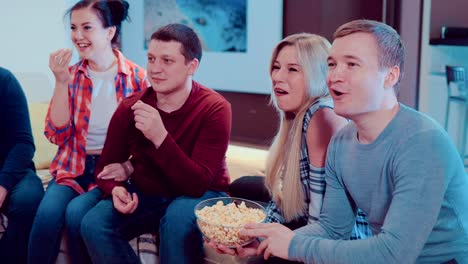Gesellschaft-von-Freunden-vor-dem-Fernseher-mit-popcorn