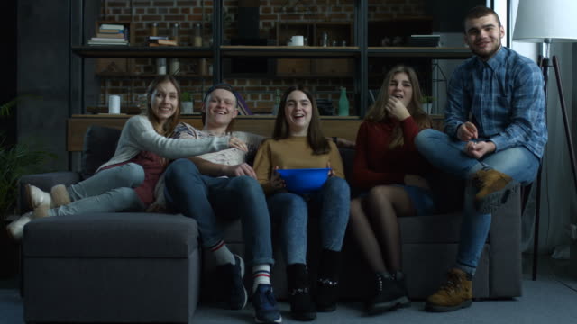 Group-of-teenagers-watch-comedy-movie-with-popcorn