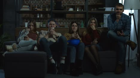 Group-of-friends-watching-horror-movie-at-home