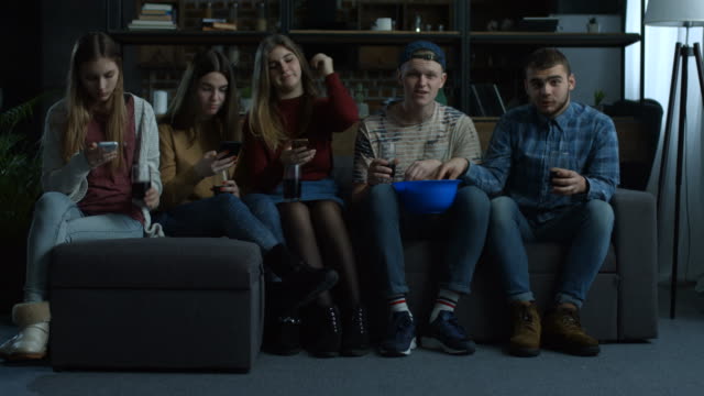 Group-of-young-friends-watching-sport-tv-at-home