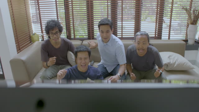Gruppe-der-asiatischen-Wohnung-paart-sich-gerade-sportlichen-Wettkampf-im-Fernsehen-zu-Hause