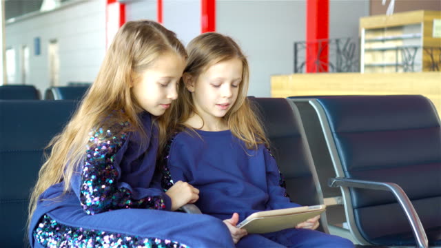 Little-adorable-girls-in-airport-near-big-window