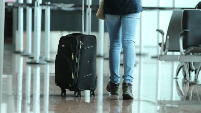 Person-zieht-Koffer-am-Flughafen.-Frau-mit-Gepäck-in-4K