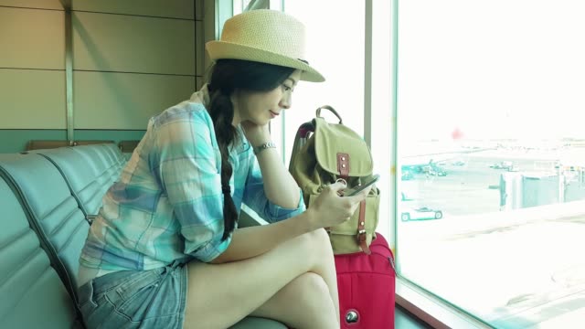 Passenger-woman-in-airport-using-smartphone