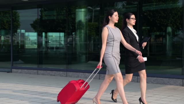 two-asian-business-manager-carrying-suitcase