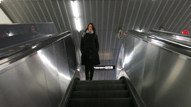Frau-auf-moderne-elektrische-Rolltreppe-Treppe-absteigen.-Mädchen,-die-hinunter-ein-Stand-noch-in-4K