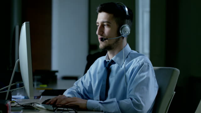 Ein-junger-Mann,-der-im-Kundenservice-oder-in-einigen-Flughafenbahnhof-Kontrollturm-arbeiten,-beantwortet-Anrufe-auf-Handy-Kunden-mit-einem-Lächeln-Tag-und-Nacht.