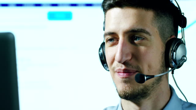 A-young-man,who-work-in-customer-service-or-in-some-airport-control-tower-station,-answers-calls-to-phone-customers-with-a-smile-day-and-night.