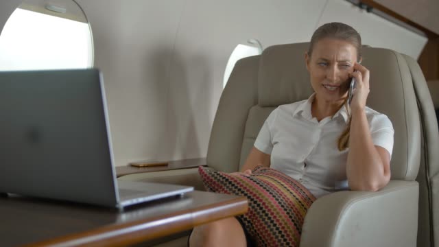 Happy-lady-speaking-about-luxury-journey-inside-of-private-jet