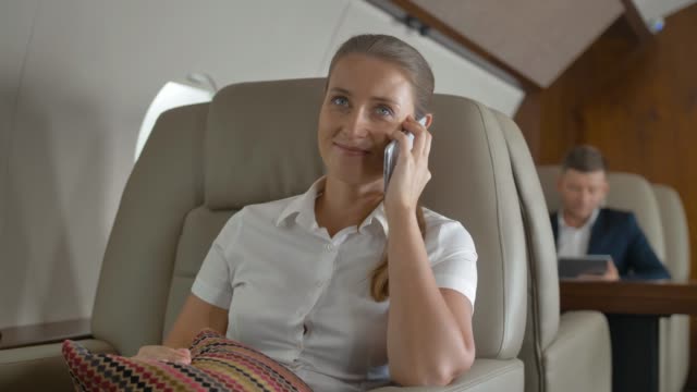 Sweet-female-speaking-about-luxury-journey-inside-of-private-jet