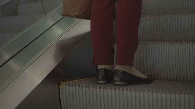 Girl-on-the-escalator.-Phone-sticking-out-of-the-bag.