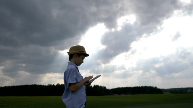 boy-enjoys-nature-view-and-uses-tablet,-artist,-dreamer