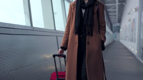 Businesswoman-on-airport-talking-on-the-smartphone-while-walking-with-hand-luggage-in-train-station-or-airpot-going-to-boarding-gate.-Girl-using-mobile-phone-for-conversation.