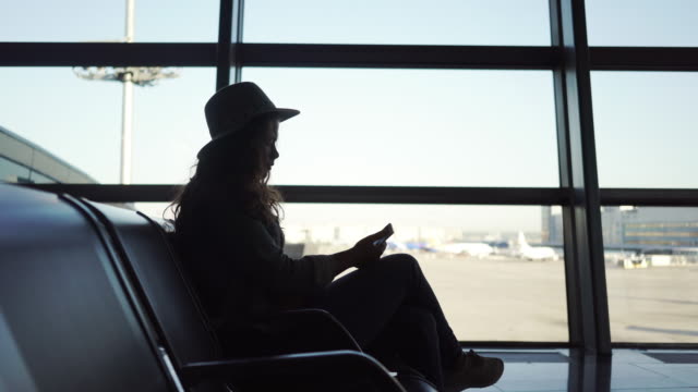 Young-woman-using-smartphone-in-airport