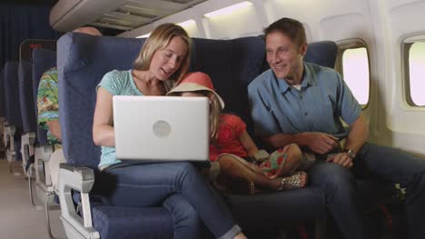 Familie-mit-Laptop-im-Flugzeug